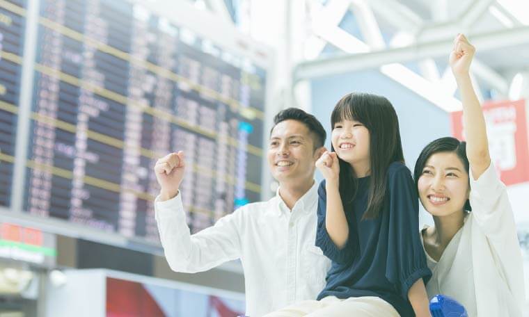 空港内でガッツポーズをする家族3人