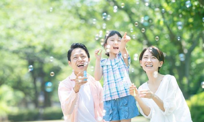 家族3人がシャボン玉で遊ぶ様子