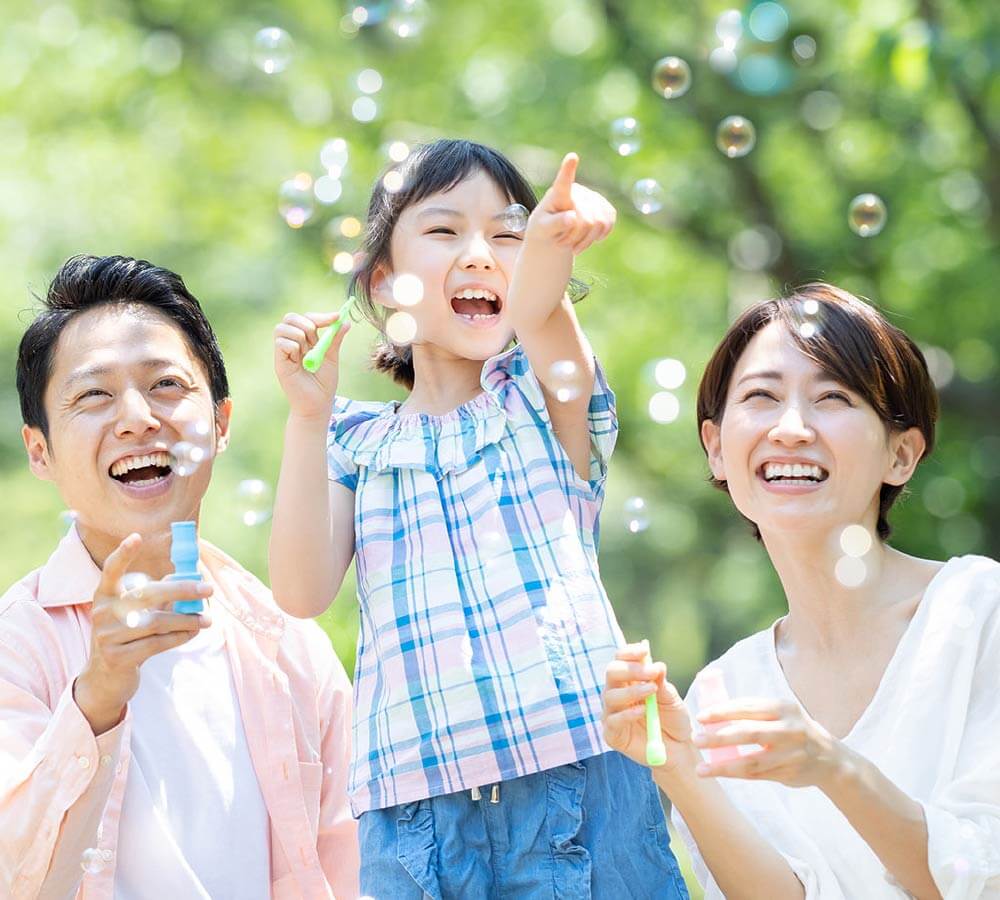 家族3人がシャボン玉で遊ぶ様子