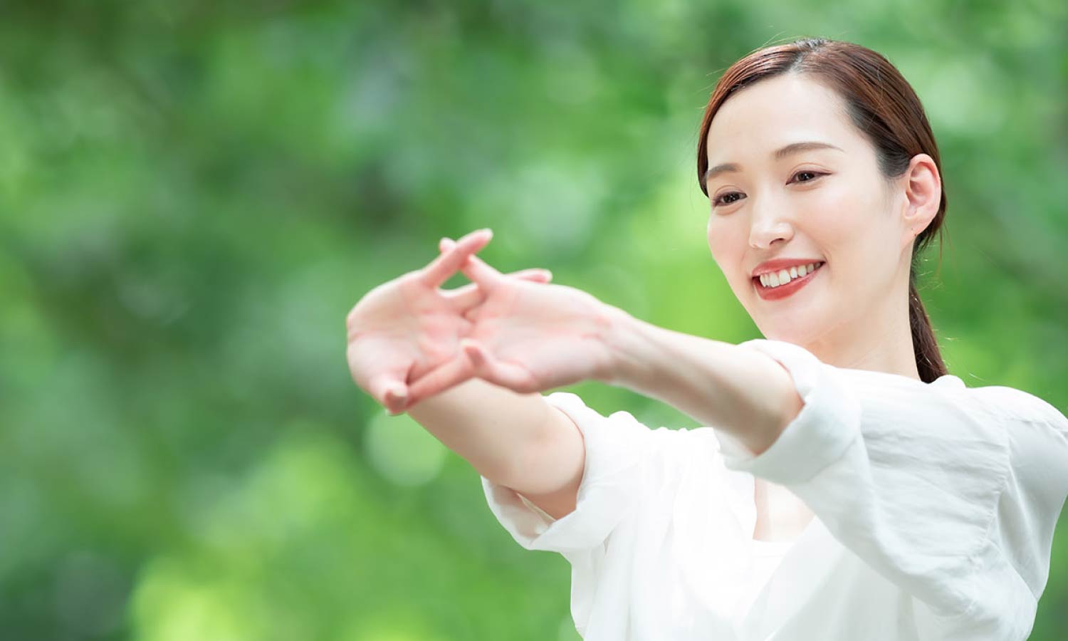 女性が指を重ねて前に伸ばす様子
