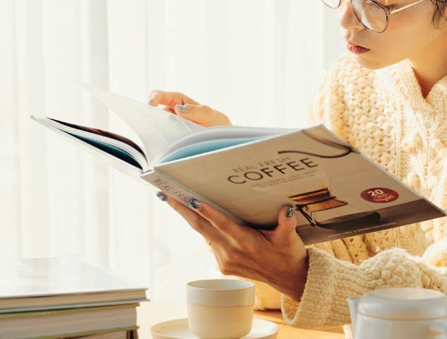 部屋でコーヒーを飲みながら読書をしている様子